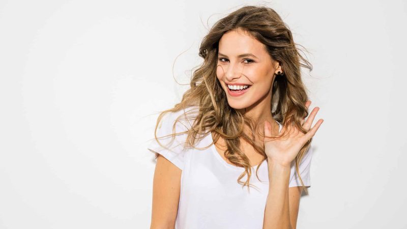 portrait of young woman with nice hair smiling to camera on whit